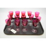 A set of fourteen clear and cranberry glass stemmed wine glasses.