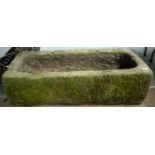 A stone composite trough garden planter.