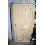 A 19th Century stripped pine floor standing corner cupboard.