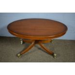 A reproduction oval yew wood pedestal coffee table, by Bradley Furniture.