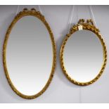 Two mid/late 20th Century decorative oval gold-painted mirrors.