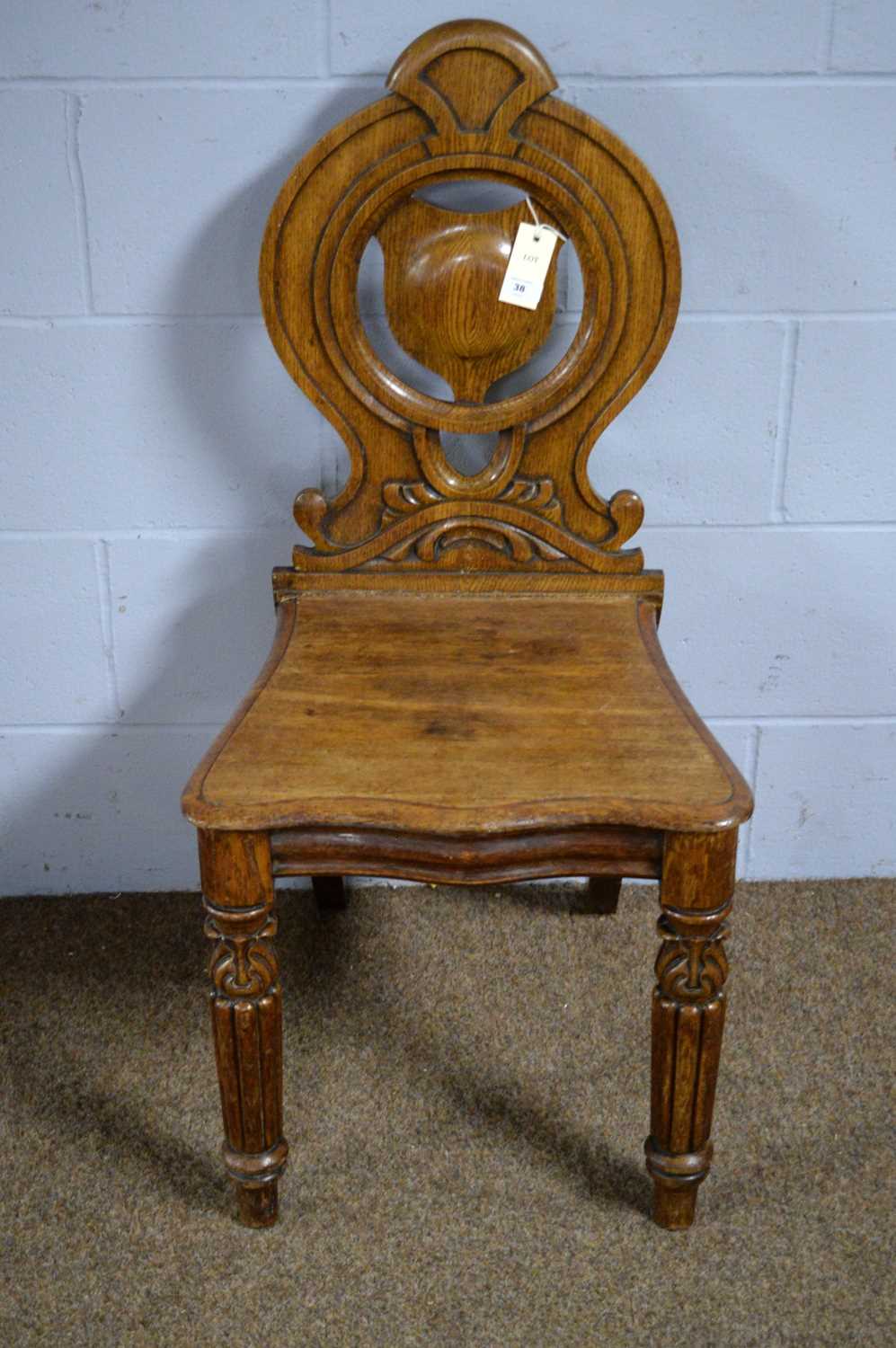 A carved oak hall chair, by Priest of Blackfriars.