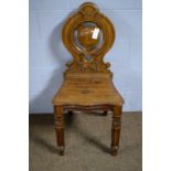 A carved oak hall chair, by Priest of Blackfriars.