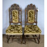 A pair of ornate Victorian carved oak dining chairs.