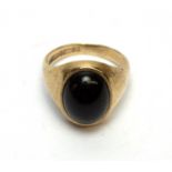 An onyx cabochon and 9ct yellow gold ring,