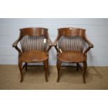 A pair of early 20th Century oak bow-back smokers chairs.