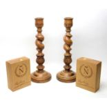 A pair of Mulberry carved and turned wood candlesticks