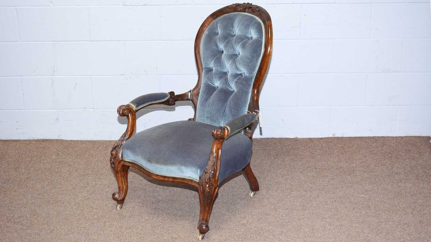 A Victorian carved walnut and button-back easy chair.