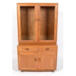 Ercol: an elm Windsor glazed cabinet,.