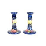 A matched pair of Moorcroft Wisteria pattern candlesticks