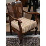 A Continental oak open arm chair with cane panelled back