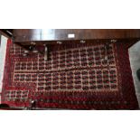 A Persian Hatchi Belouch rug, buff ground with repeating motif