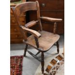 An antique provincial elm seated elbow chair on turned legs