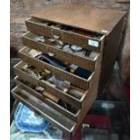 A six-drawer table-top chest, containing a quantity of sundry collectables