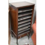 A mahogany music cabinet with open shelves over a single drawer