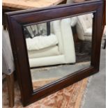 A rectangular wall mirror in stained hardwood frame