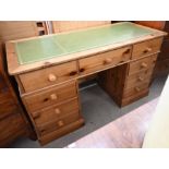 A stained pine nine-drawer twin pedestal desk