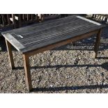 A weathered teak garden table by Barlow Tyrie