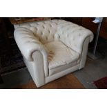 A contemporary buttoned cream leather armchair