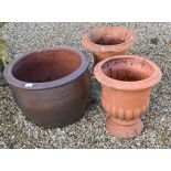 Three weathered terracotta garden planters