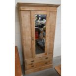 An antique stripped pine wardrobe