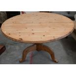 A waxed pine circular dining table