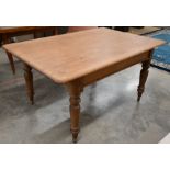 A stained pine kitchen/dining table