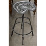 A cast iron tractor seat bar stool, pitted aged metal finish