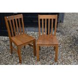 A set of eight stained hardwood slatback dining chairs