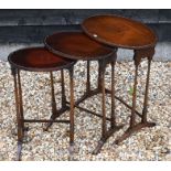 An nest of three Edwardian red walnut oval tables