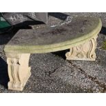 A weathered three piece cast stone garden bench