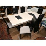 A contemporary simulated cream and black marble dining table and chairs