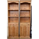 A pair of waxed pine narrow bookcases