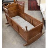 An early 20th century oak rocking cradle