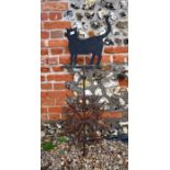 A wrought iron weather vane surmounted by cat silhouette