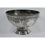 A late Victorian embossed silver punch-bowl on stemmed foot,