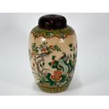 A 19th century Chinese famille verte ovoid jar with reticulated hardwood cover