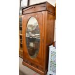 An antique chestnut wardrobe with bevelled oak mirrored door over two drawers