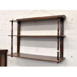 A mahogany three-tier wall shelf with turned pillars