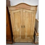 A Continental waxed pine dome-top wardrobe