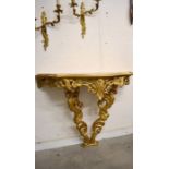 A gilt painted floral and foliate carved serpentine console table