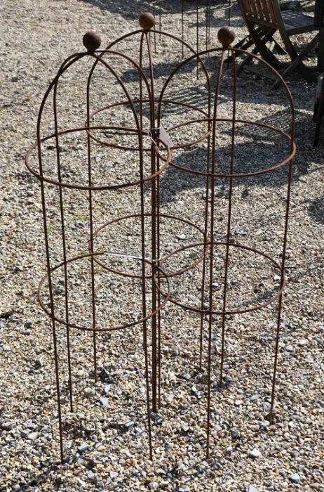 A trio of weathered steel ball head garden obelisks, 117 cm x 34 cm