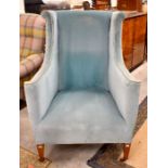 An Edwardian blue upholstered wing back armchair