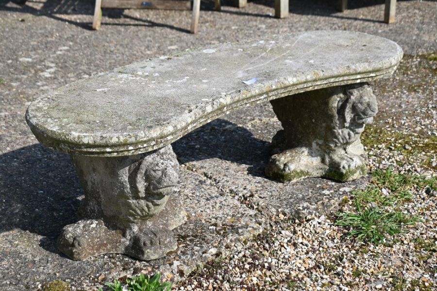 A weathered and reconstituted cast stone garden bench