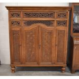 An Indonesian carved and pierced hardwood cabinet