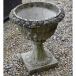 A weathered reconstituted stone garden urn, 58 cm high