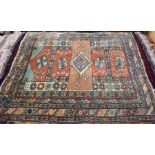 A Turkish terracotta and teal geometric design rug