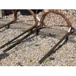 A bundle of ten large curved weathered steel plant supports, 104 cm x 58 cm