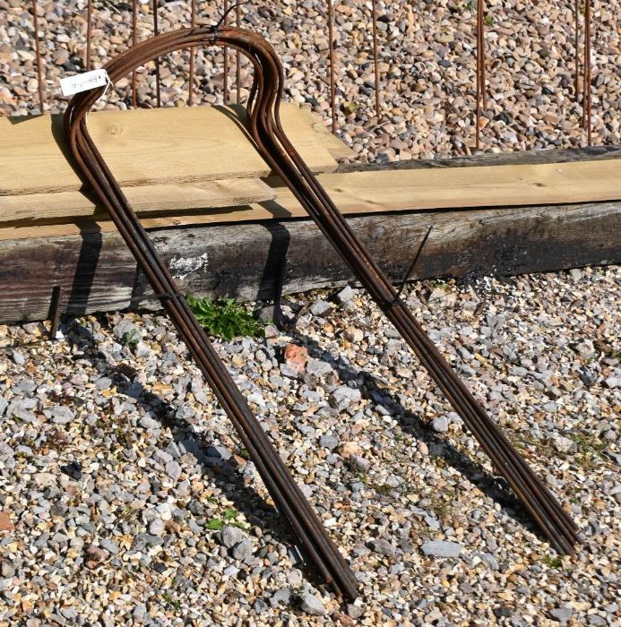 A bundle of ten tall curved weathered steel plant supports, 90 cm x 36 cm