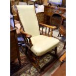 An oak framed rocking chair with cream vinyl upholstery